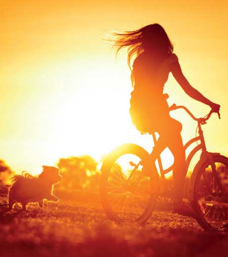 woman riding bike with puppy